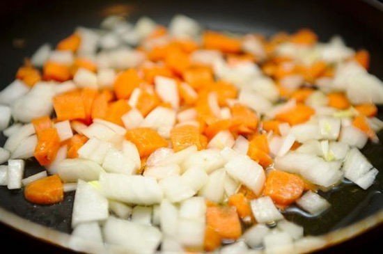 В кастрюлю с горохом и водой добавляем морковь кубиками и лук